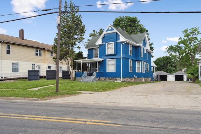 612 Lansing Ave, Jackson, MI 49202 - victorian house with an outdoor structure, a front lawn, and a garage
