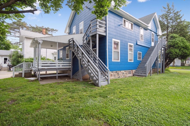 612 Lansing Ave, Jackson, MI 49202 - back of property with stairs, a lawn, and a deck
