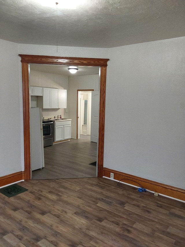 612 Lansing Ave, Jackson, MI 49202 - kitchen with electric range, freestanding refrigerator, dark wood finished floors, and white cabinets