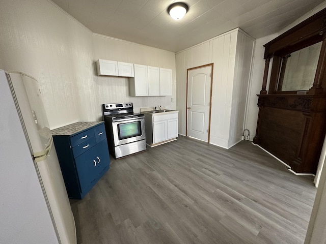 612 Lansing Ave, Jackson, MI 49202 - kitchen featuring electric range, freestanding refrigerator, blue cabinets, dark wood-type flooring, and white cabinetry