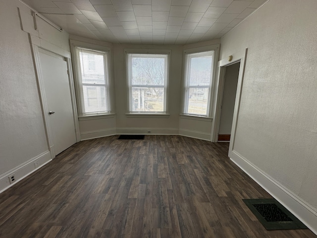 612 Lansing Ave, Jackson, MI 49202 - unfurnished bedroom featuring dark wood-style floors and a textured wall