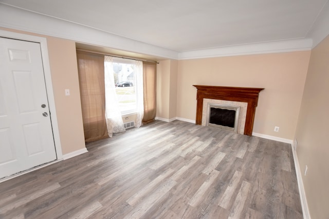 unfurnished living room featuring baseboards, a fireplace, and wood finished floors