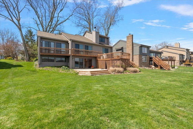 rear view of house featuring a deck, stairway, and a yard