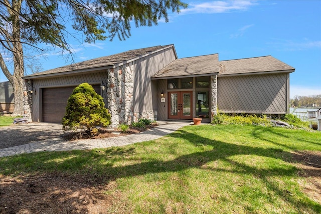 mid-century modern home featuring a front lawn, stone siding, a garage, and french doors