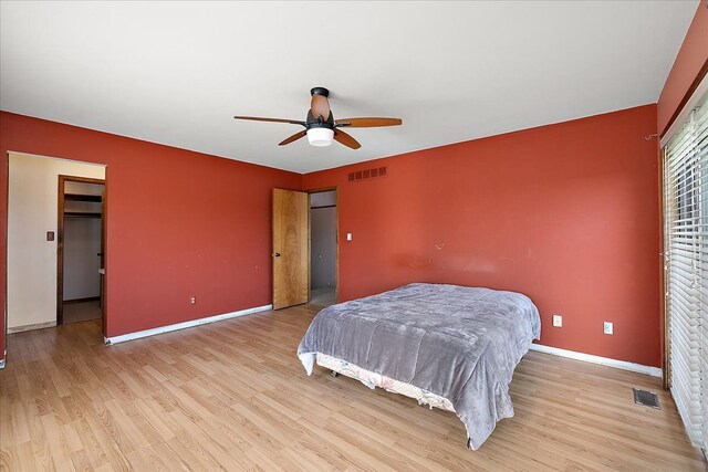 bedroom with baseboards, visible vents, and light wood finished floors