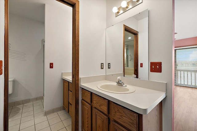 bathroom with tile patterned floors, toilet, vanity, and baseboards