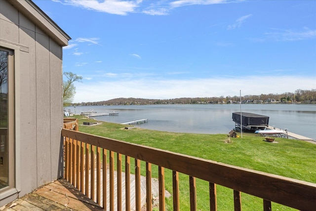 wooden terrace featuring a dock, a yard, and a water view