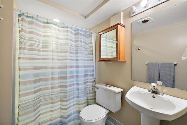 full bath with visible vents, curtained shower, toilet, and a sink