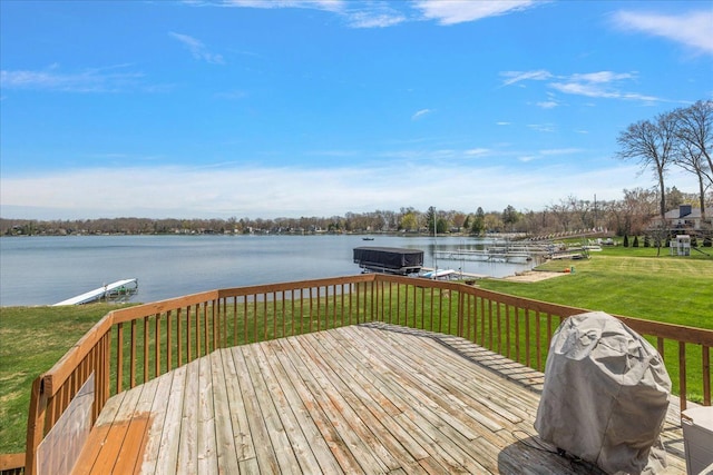 wooden deck featuring a yard, a boat dock, a water view, and boat lift