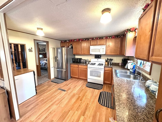 13027 Norman Rd, Brockway, MI 48097 - kitchen with white appliances, a sink, light wood-style flooring, a textured ceiling, and brown cabinets