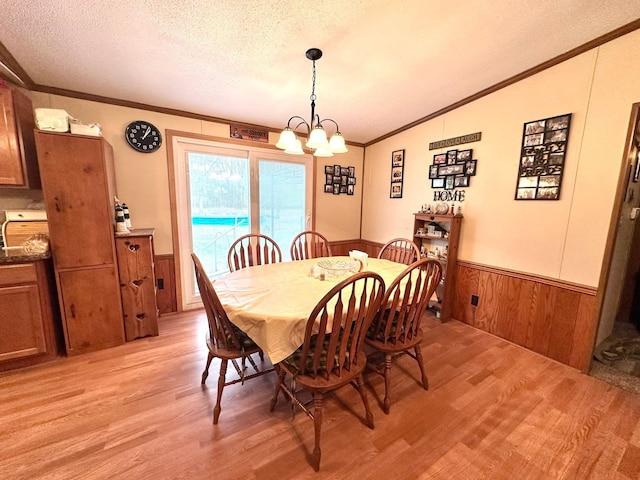 13027 Norman Rd, Brockway, MI 48097 - dining room with light wood-type flooring, a wainscoted wall, a textured ceiling, a chandelier, and ornamental molding
