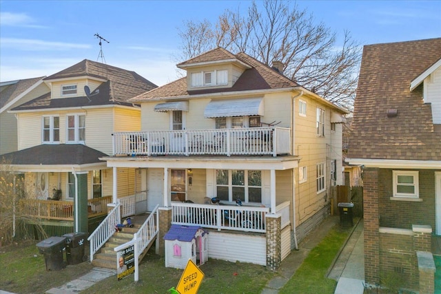 view of front of home with a porch, a chimney, and a shingled roof