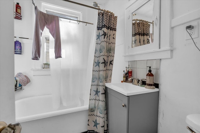 full bathroom with shower / tub combo, toilet, vanity, and decorative backsplash
