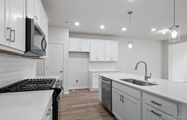 1466 Addison Cir, Walled Lake, MI 48390 - kitchen featuring appliances with stainless steel finishes, decorative backsplash, white cabinetry, light countertops, and decorative light fixtures