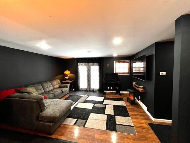 living area with baseboards and wood finished floors