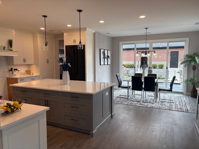 1219 N Main St, Rochester, MI 48307 - kitchen with black refrigerator, light countertops, backsplash, and dark wood-style floors