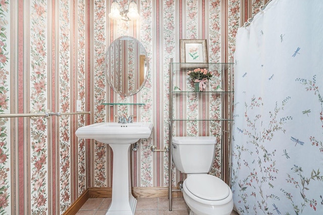 16396 M-89, Augusta, MI 49012 - bathroom featuring tile patterned flooring, toilet, baseboards, wallpapered walls, and a sink