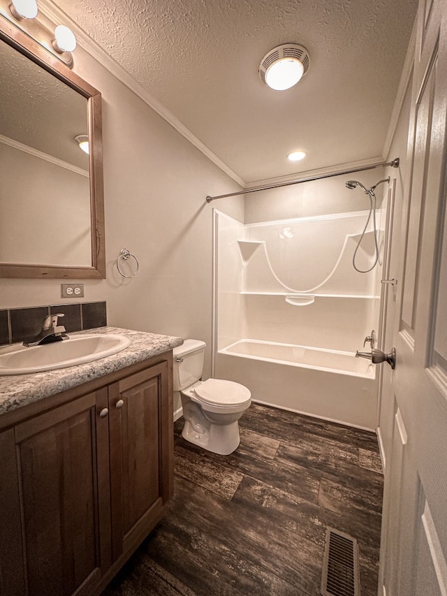 bathroom featuring a textured ceiling, wood finished floors, ornamental molding, and visible vents