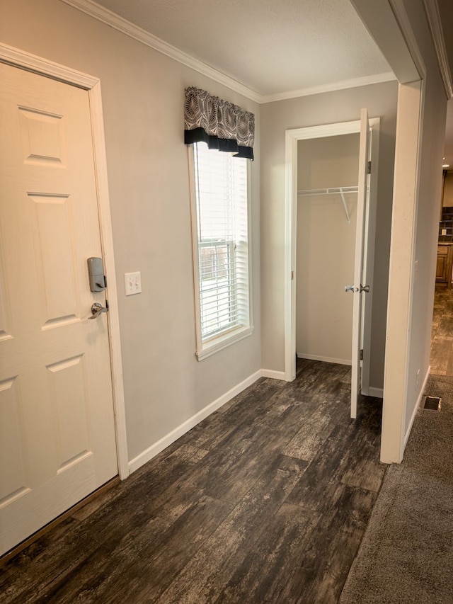 unfurnished bedroom featuring a closet, baseboards, crown molding, visible vents, and dark wood finished floors