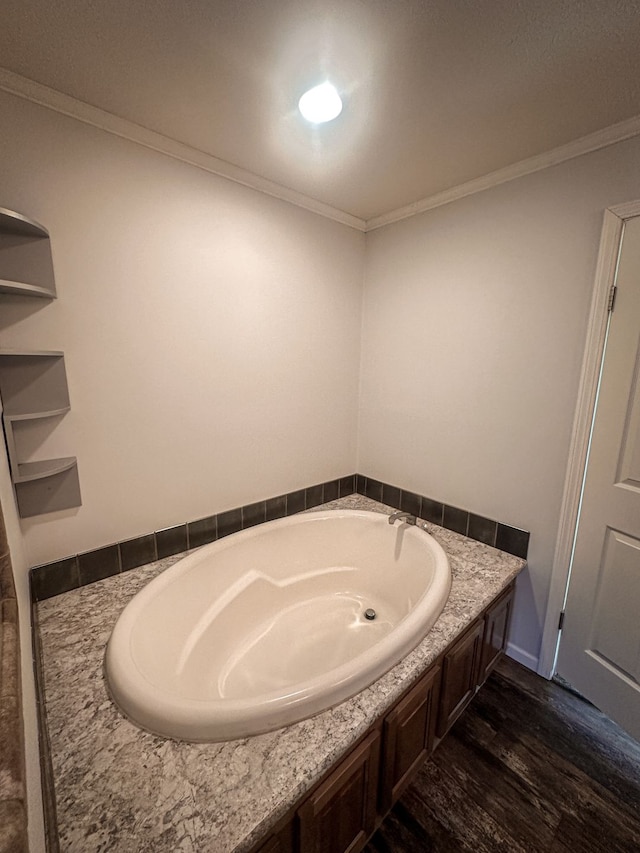 bathroom with a garden tub, crown molding, and wood finished floors