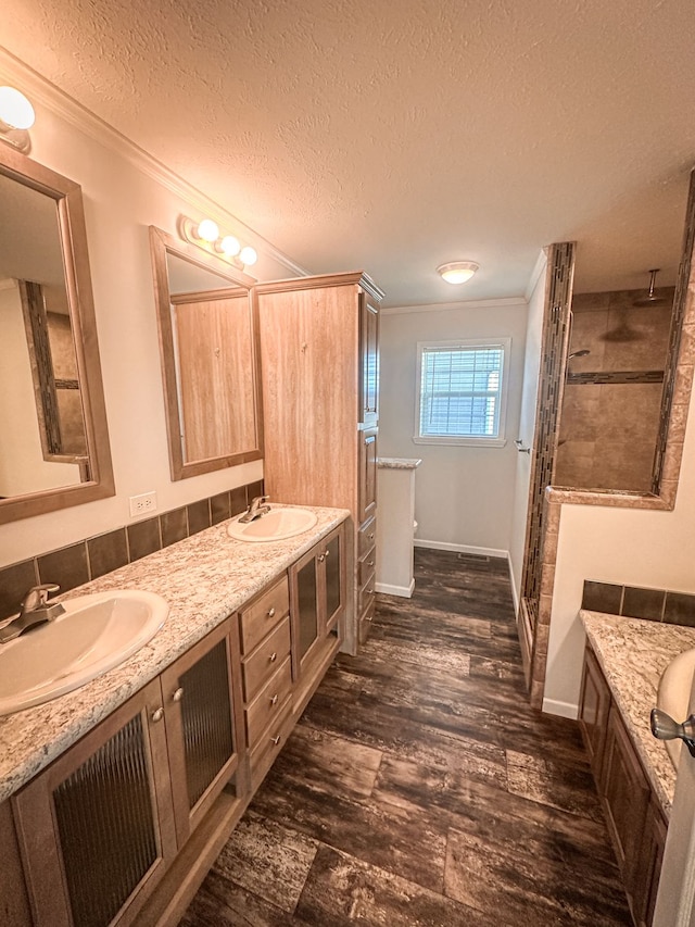 full bath with a sink, ornamental molding, and a stall shower
