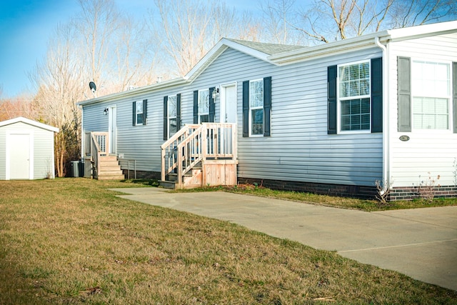 view of front of house featuring a front yard, crawl space, an outdoor structure, a storage unit, and central air condition unit