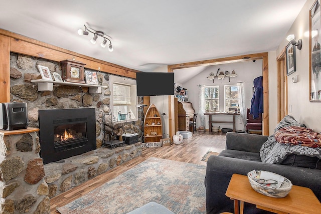 16824 Shawano Dr NE, Sand Lake, MI 49343 - living room featuring wood finished floors, vaulted ceiling, and a stone fireplace