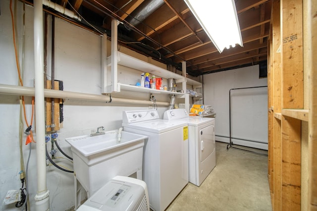washroom featuring laundry area, separate washer and dryer, a sink, and a baseboard radiator