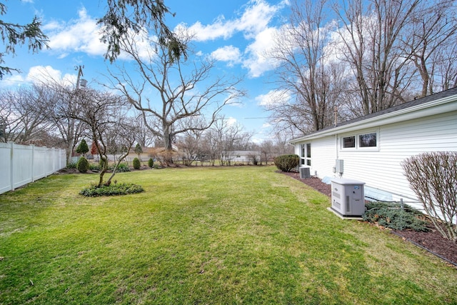 view of yard featuring central AC unit and fence