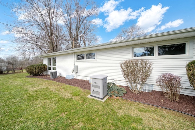back of property with a yard and central AC