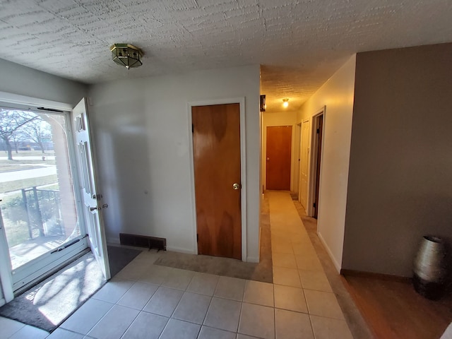 2415 Needham St, Saginaw, MI 48601 - entryway with light tile patterned flooring, baseboards, and a textured ceiling