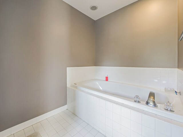 full bathroom featuring tile patterned floors, baseboards, and a bath