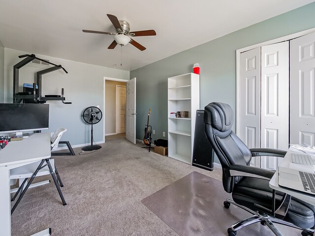 carpeted office featuring baseboards and ceiling fan