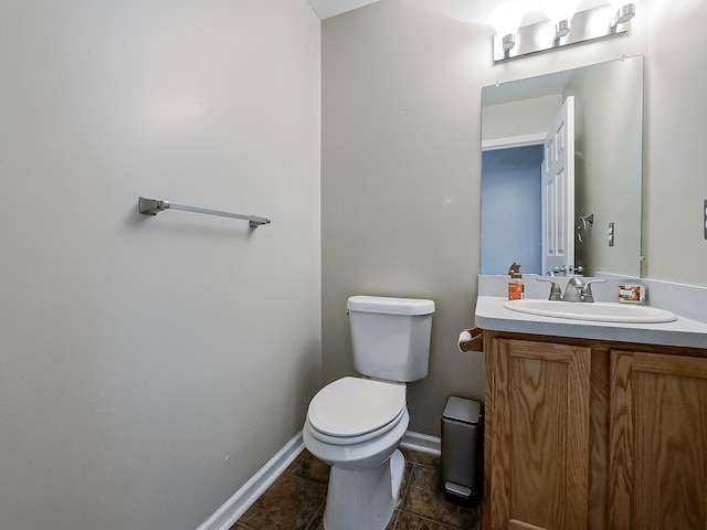 bathroom with toilet, baseboards, tile patterned floors, and vanity
