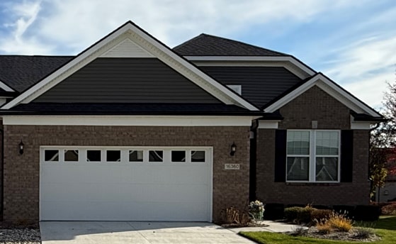 view of front facade featuring brick siding, driveway, and a garage