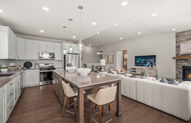 kitchen with open floor plan, dark wood-style flooring, and appliances with stainless steel finishes