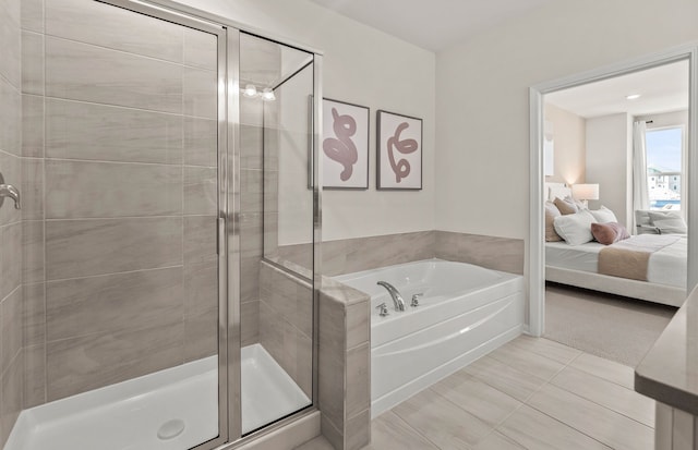 bathroom featuring a stall shower, tile patterned floors, a bath, and ensuite bath