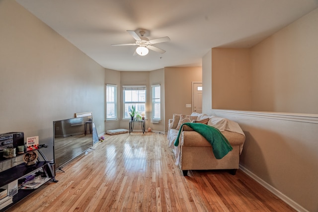 living area with ceiling fan, wood finished floors, and baseboards