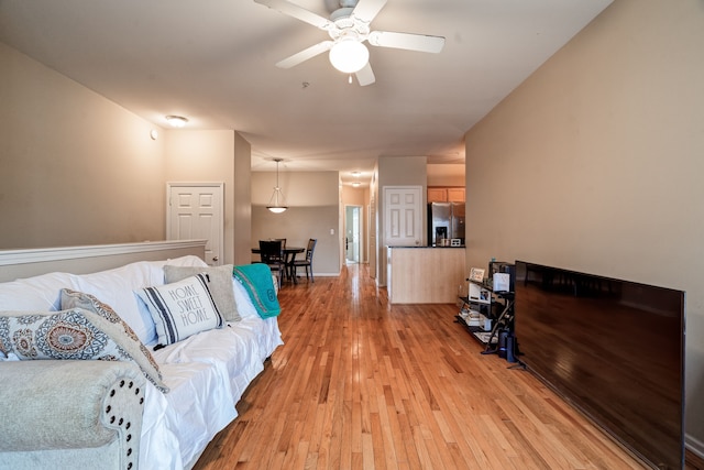 living room featuring a ceiling fan and light wood finished floors