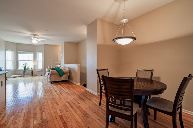 dining space featuring ceiling fan, light wood-style flooring, and baseboards