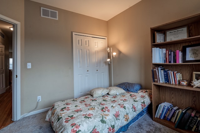 bedroom with a closet, visible vents, carpet, and baseboards