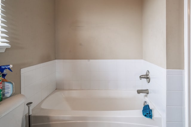 full bath featuring toilet and a bath