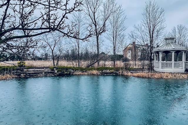 view of swimming pool with a gazebo and a water view