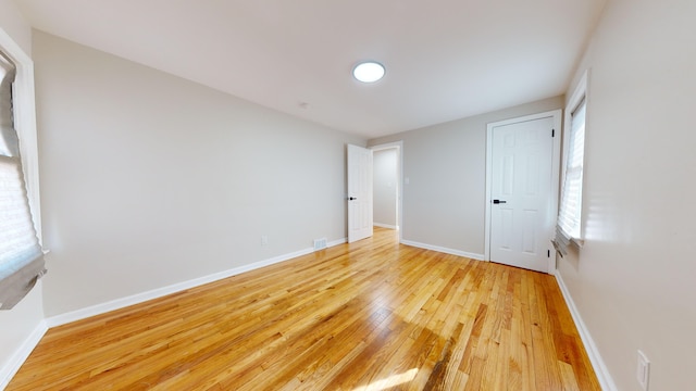 spare room featuring visible vents, baseboards, and light wood-type flooring