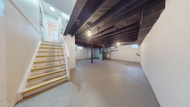 unfinished below grade area featuring stairs and heating unit