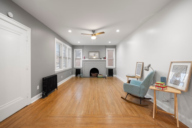 5959 Three Mile Dr, Detroit, MI 48224 - living area with a ceiling fan, a brick fireplace, radiator, baseboards, and recessed lighting