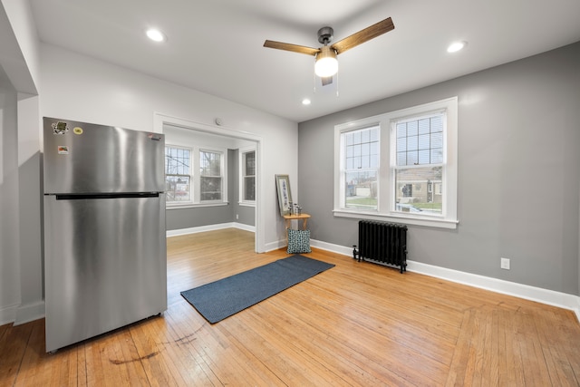 5959 Three Mile Dr, Detroit, MI 48224 - workout room with wood-type flooring, ceiling fan, baseboards, and radiator