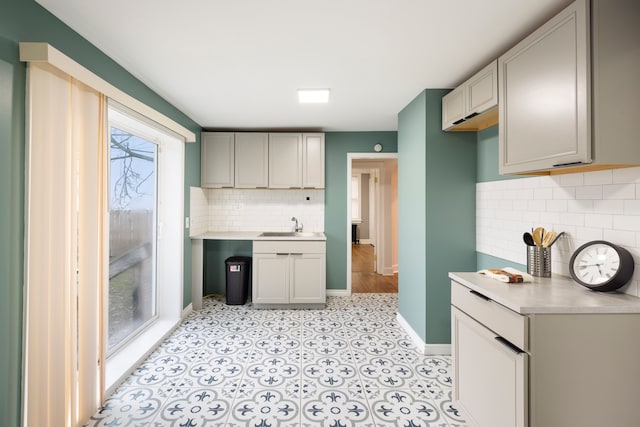 5959 Three Mile Dr, Detroit, MI 48224 - kitchen with baseboards, backsplash, light countertops, and a sink