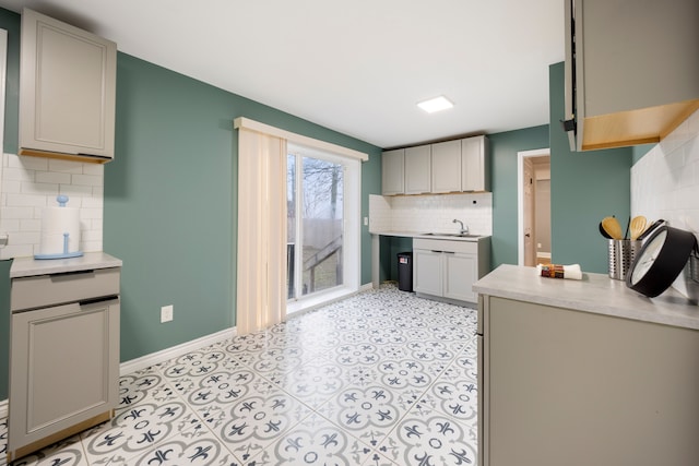 5959 Three Mile Dr, Detroit, MI 48224 - kitchen with light countertops, baseboards, gray cabinetry, backsplash, and a sink