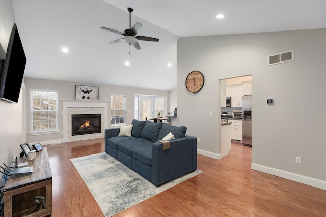 33172 Swallow Dr, Rockwood, MI 48173 - living area with high vaulted ceiling, ceiling fan, a fireplace, baseboards, and visible vents